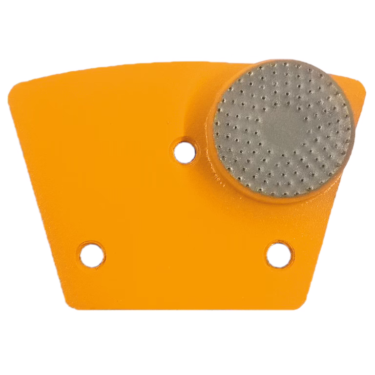 Ein Objekt mit einer orangefarbenen, dreieckigen Form, das an einer Kante ein graues, rundes Pad aufweist, das für eine bestimmte Funktion entwickelt wurde, möglicherweise im Zusammenhang mit Traktion oder Grip, was durch seine strukturierte Oberfläche angezeigt wird.