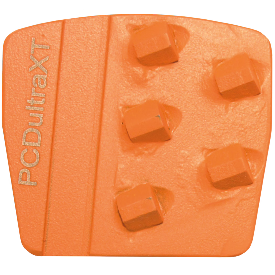 Derendinger_Dummy_75365_PCDultraXT_2019.12 Detailaufnahme eines orangefarbenen, rechteckigen Diamant-Schleifsegments für Beton- und Steinbodenbearbeitung. Das polymergebundene Segment zeigt sechs erhöhte, quadratische Schleifkörper in zwei versetzten Spalten, eine strukturierte Oberfläche und eine links verlaufende Rippe mit der Prägung 'PCDultraxT'. Leichte Gebrauchsspuren und Harzreste sind sichtbar; die Aufnahme ist gleichmäßig ausgeleuchtet vor weißem Hintergrund.